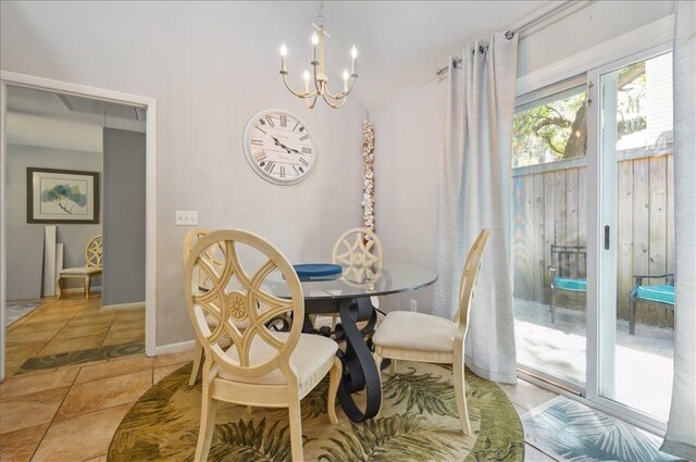 dining area with a chandelier, vaulted ceiling, light tile patterned floors, and baseboards