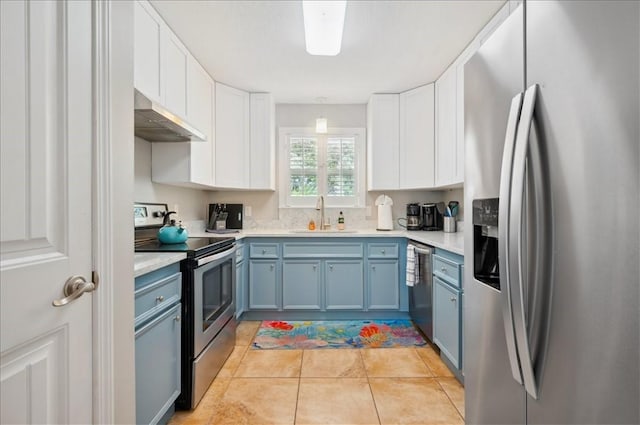 kitchen with appliances with stainless steel finishes, a sink, under cabinet range hood, and white cabinetry