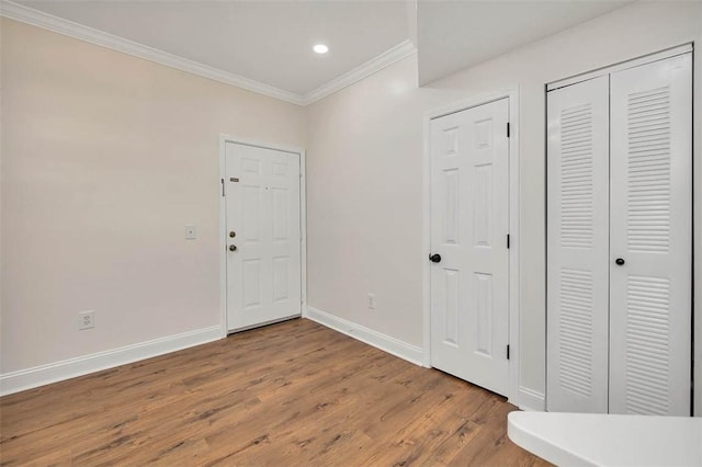 foyer featuring crown molding, wood finished floors, baseboards, and recessed lighting