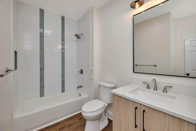 bathroom with toilet, wood finished floors, tub / shower combination, and vanity