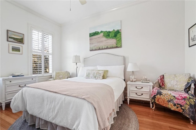 bedroom featuring ceiling fan, light hardwood / wood-style flooring, and ornamental molding