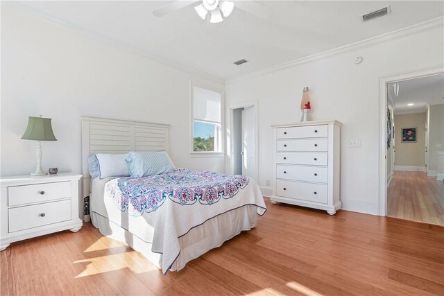 bedroom featuring ceiling fan, light hardwood / wood-style flooring, and crown molding