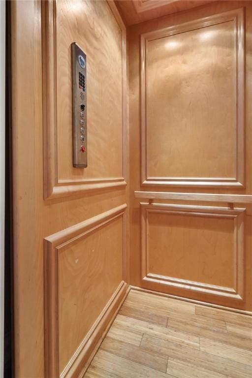 details featuring elevator and hardwood / wood-style flooring