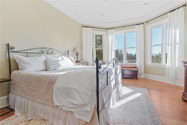 bedroom with ornamental molding and light hardwood / wood-style flooring