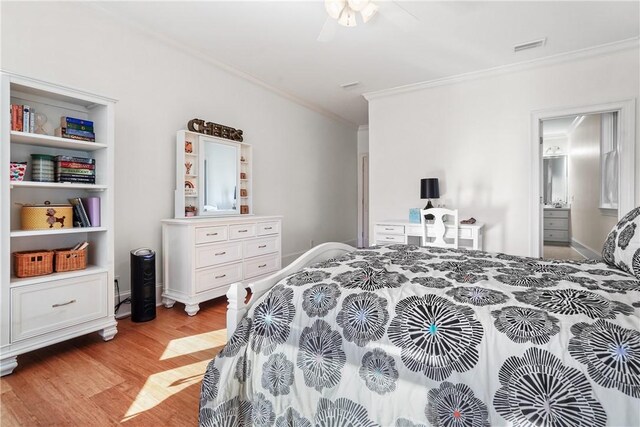 bedroom with ceiling fan, light wood-type flooring, crown molding, and connected bathroom