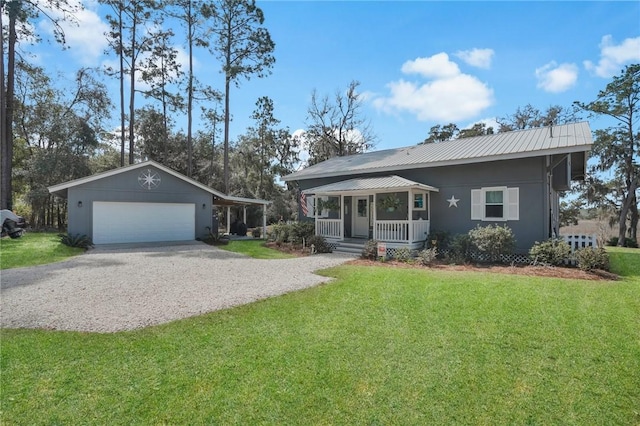 view of front facade featuring metal roof, a porch, a garage, driveway, and a front yard