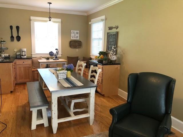 dining room featuring crown molding, light wood-style floors, and baseboards