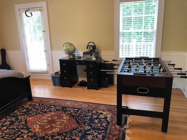 rec room featuring wood finished floors and wainscoting