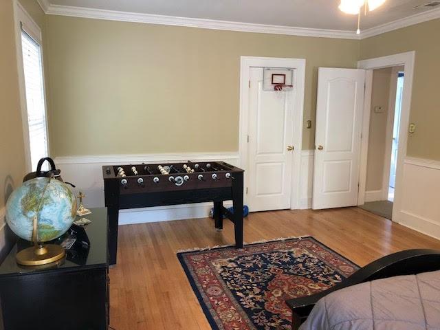 interior space with wood finished floors and ornamental molding