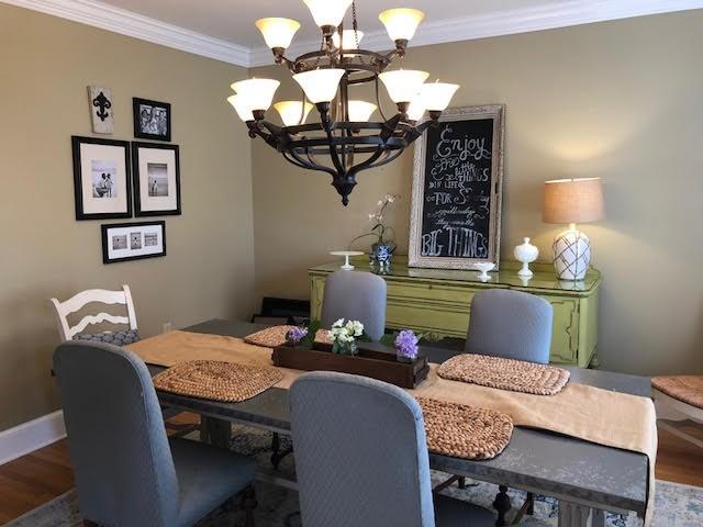 dining area featuring wood finished floors, a chandelier, and crown molding