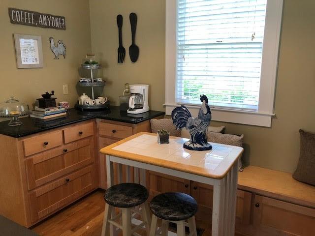 kitchen featuring tile countertops, a kitchen breakfast bar, a peninsula, and wood finished floors