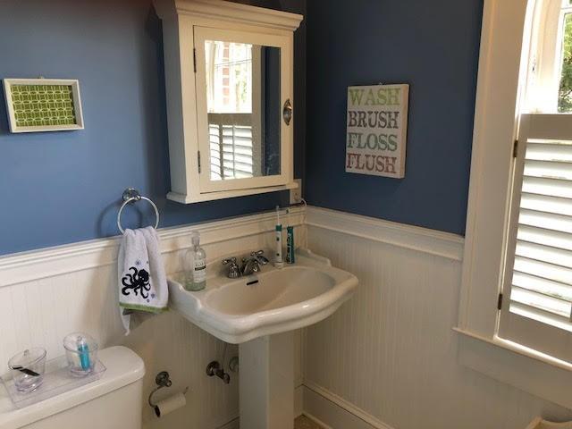 half bath featuring a wainscoted wall and toilet