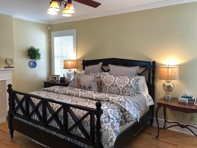 bedroom featuring wood finished floors and ornamental molding