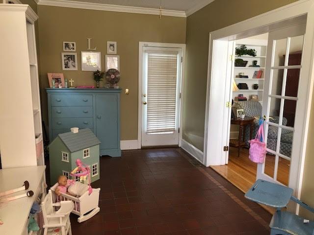 doorway to outside with baseboards and ornamental molding