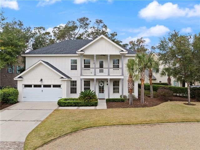 view of front of home featuring a front yard, a balcony, and a garage