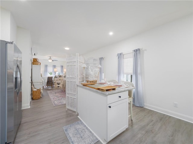 1007 Elbert Ext, Darien, GA 31305 - kitchen featuring stainless steel fridge with ice dispenser, white cabinetry, light wood-type flooring, a ceiling fan, and light countertops