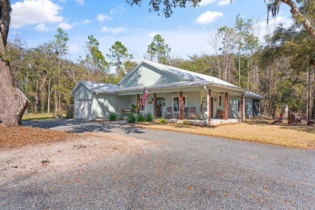 view of front of house with driveway, covered porch, and an attached garage