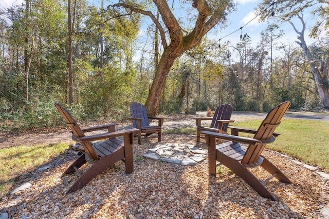 exterior space featuring a forest view and a fire pit