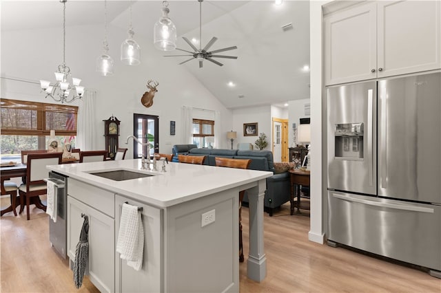 kitchen with light wood finished floors, visible vents, open floor plan, stainless steel refrigerator with ice dispenser, and a sink