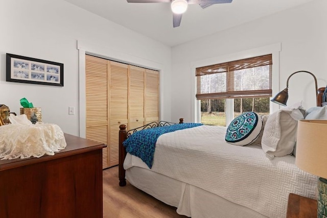 bedroom featuring ceiling fan, a closet, and light wood-style floors