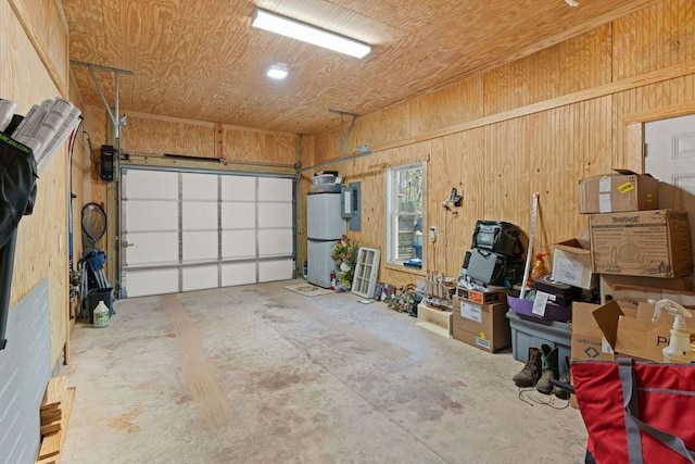 garage featuring water heater and wooden walls