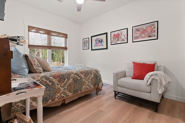 bedroom with ceiling fan, wood finished floors, and baseboards