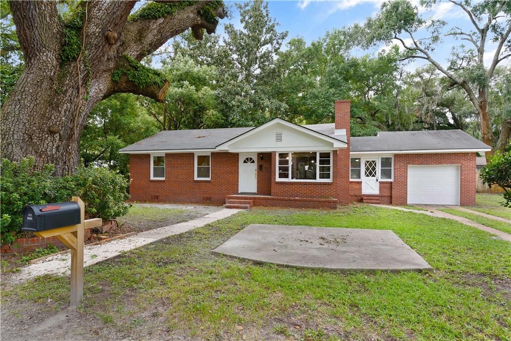 ranch-style house featuring a garage and a front lawn