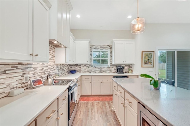 kitchen with light wood-type flooring, tasteful backsplash, stainless steel appliances, decorative light fixtures, and white cabinetry