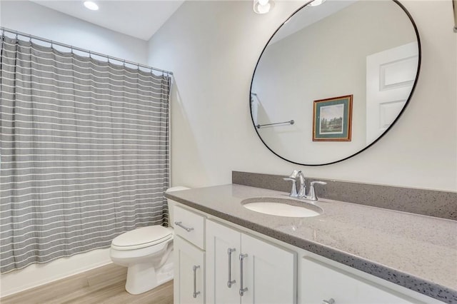 bathroom featuring vanity, hardwood / wood-style flooring, toilet, and curtained shower