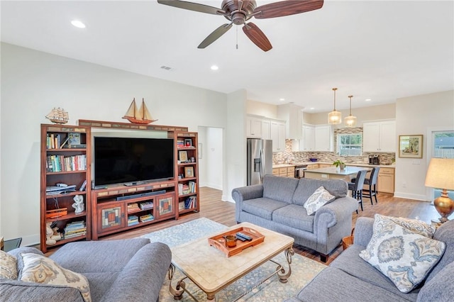 living room featuring ceiling fan and light wood-type flooring