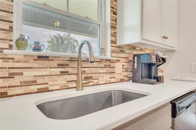 interior details with dishwasher, decorative backsplash, white cabinetry, and sink