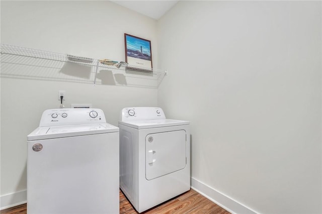 laundry area featuring light wood-type flooring and washing machine and clothes dryer