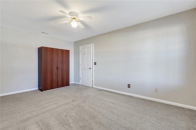 carpeted empty room with ceiling fan and a textured ceiling