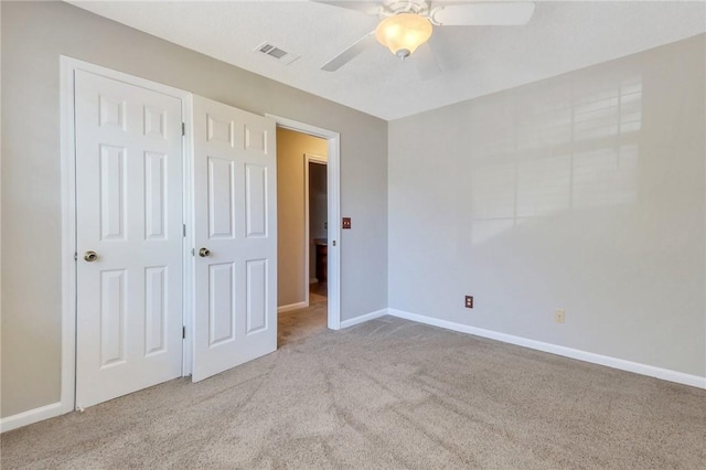 unfurnished bedroom featuring light colored carpet and ceiling fan