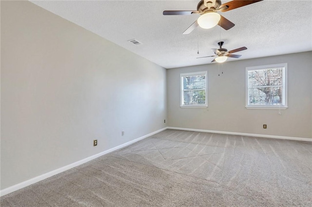 spare room with light colored carpet and a textured ceiling