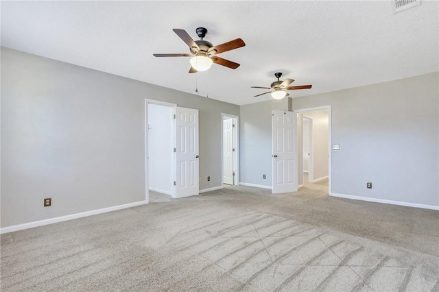 carpeted empty room featuring ceiling fan and a textured ceiling