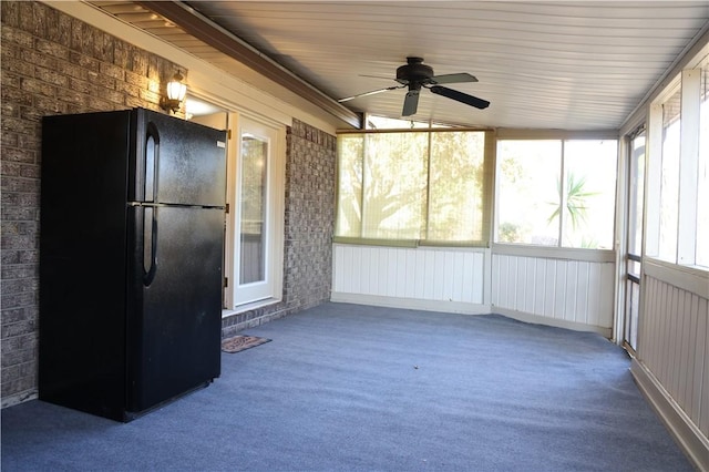 unfurnished sunroom featuring ceiling fan