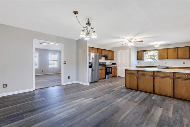 kitchen with ceiling fan, appliances with stainless steel finishes, hanging light fixtures, plenty of natural light, and dark hardwood / wood-style floors