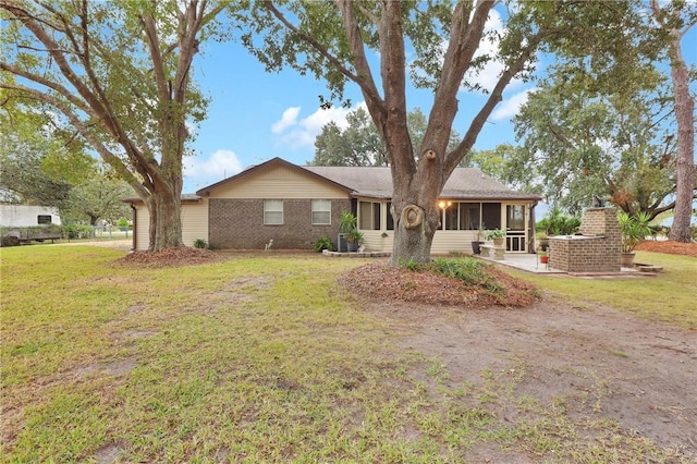 rear view of house with a yard, a sunroom, and a patio