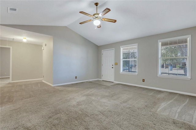 carpeted spare room featuring vaulted ceiling and ceiling fan