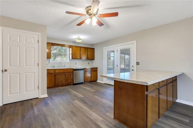 kitchen featuring dark hardwood / wood-style floors, stainless steel dishwasher, a textured ceiling, and kitchen peninsula