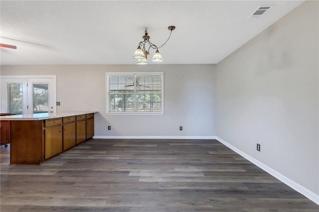 unfurnished dining area with dark hardwood / wood-style floors, a chandelier, and a wealth of natural light