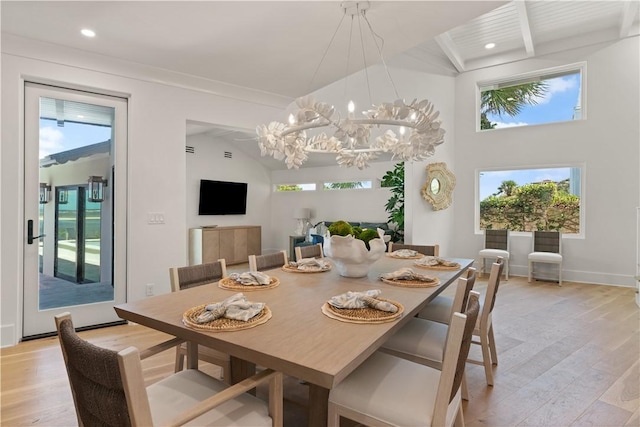 dining area featuring light wood-type flooring, lofted ceiling, and a notable chandelier