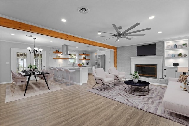 703 Wayne St, Darien, GA 31305 - living room with recessed lighting, ornamental molding, light wood-style floors, a ceiling fan, and a chandelier