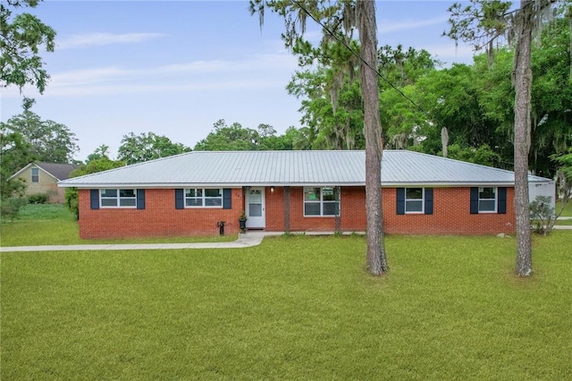 703 Wayne St, Darien, GA 31305 - single story home with a front yard, brick siding, and metal roof