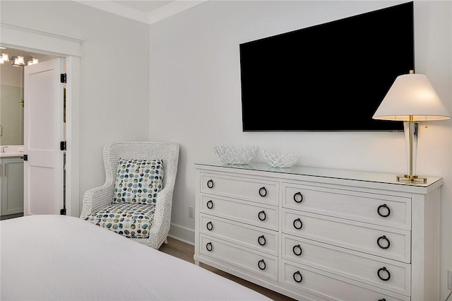 bedroom with ensuite bathroom and hardwood / wood-style floors