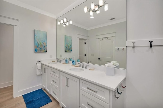 bathroom with crown molding, hardwood / wood-style floors, and vanity