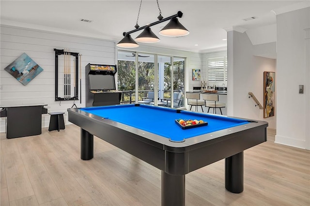 game room featuring wood walls, light wood-type flooring, crown molding, and pool table