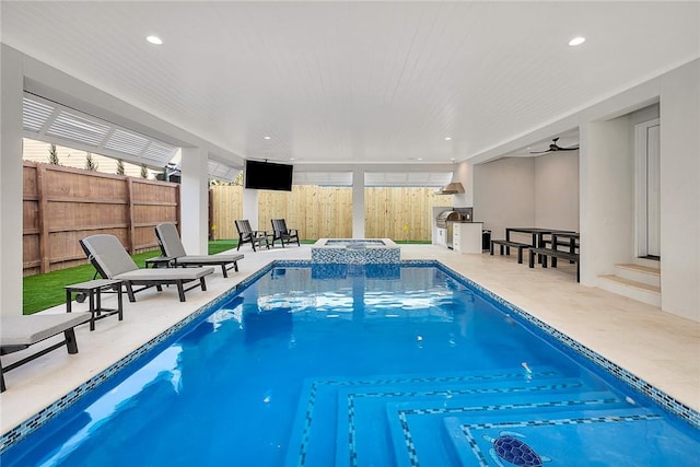 view of swimming pool with ceiling fan and an in ground hot tub