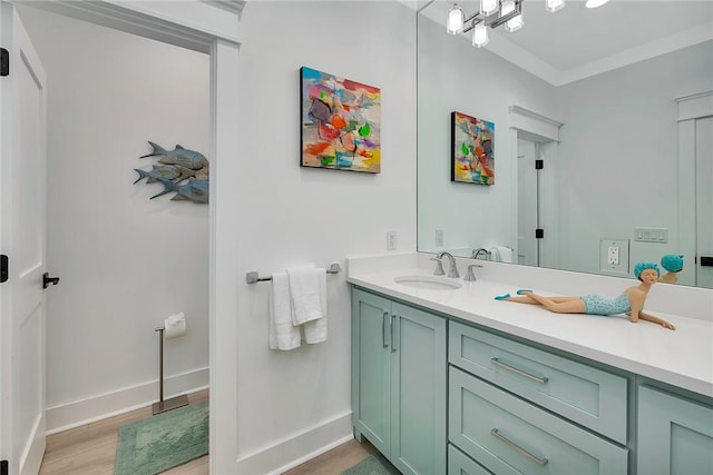 bathroom featuring hardwood / wood-style floors, vanity, and ornamental molding